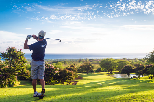 Image of man golfing overlooking the golf course and ocean
