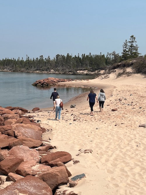 people walking on a white sand beach on PEI