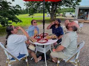 people enjoying oysters and cider on a patio on PEI